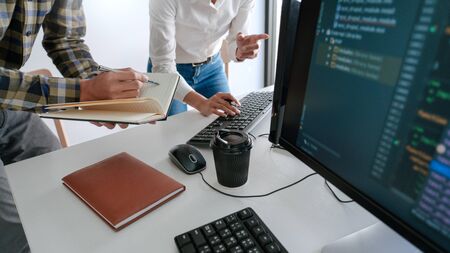 Pensive programmer working on desktop pc programming code technologies or website design at office Software Development Companyの写真素材