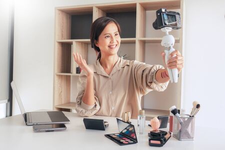 beautiful asian woman professional beauty vlog or blogger present cosmetics and applying make-up in front camera for recording videoの写真素材