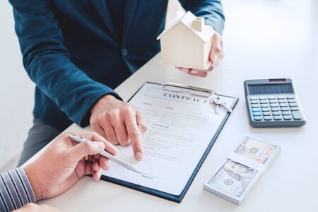 Sale representative offer house purchase contract to buy a house or apartment or discussing about loans and interest ratesの写真素材