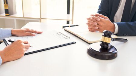 Male lawyer or judge consult with client check contract papers recommend legal proposals, Law services concept.の写真素材
