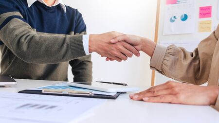 Good deal career and placement concept, successful young businessmen shaking hands after successful negotiation in modern officeの写真素材
