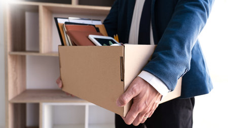 Businessmen are holding resignation document and packing personal company on brown cardboard box changing work, resign conceptの写真素材