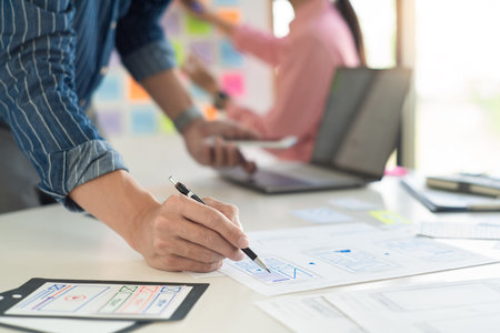 Graphic designers team work together with UX UI designer planning application template layout mobile...