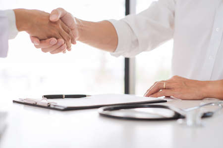 Attractive young beautiful asian woman working with laptop and document talking smartphone at the indoors living room office as a freelancer, e-coaching working, remotely or work from home conceptの写真素材