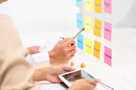 Creative group of business people brainstorming use sticky notes to share idea on glass window or...