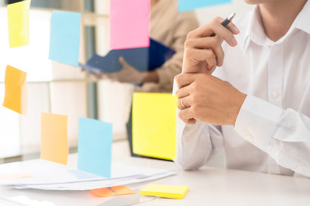 business people planning startup project placing sticky notes session to share idea on glass wall,...