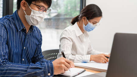 Group of Teamwork Asian business People Wearing Protective face Mask In Office During Pandemic coronavirus COVID-19, New Normal and Social distancing concept.の写真素材