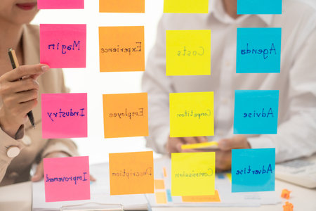 business people planning startup project placing sticky notes session to share idea on glass wall,...