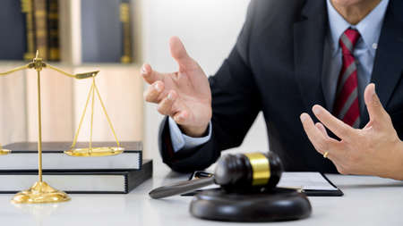 Client with his partner lawyers or attorneys discussing discussing a document or contract agreement working at table in office, Good service cooperationの写真素材