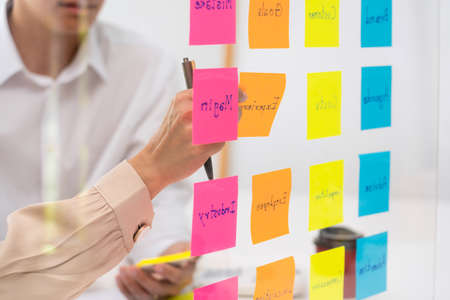 business people planning startup project placing sticky notes session to share idea on glass wall, Strategy Analysis Office Conceptの写真素材