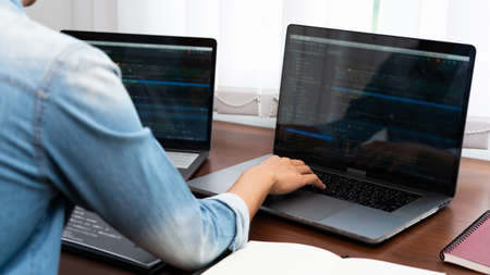 Programmer or software developer Typing New Lines of Code, coding technologies working at wooden industrial interior work place stationの写真素材