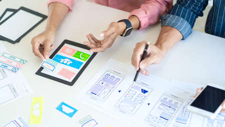 Graphic designers team work together with UX UI designer planning application template layout mobile phone prototype, User experience concept.の写真素材