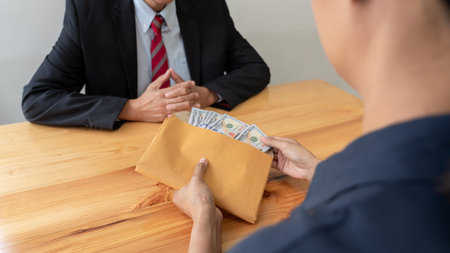 Businessman reciving money United States Dollars bills to corruption from his partner in business at...