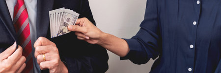 Businessman reciving money United States Dollars bills to corruption from his partner in business at...