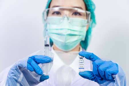 Doctor, scientist, researcher hand in blue gloves or protective suit preparing for human clinical injection trials vaccination covid-19 coronavirus vaccination Biological hazard conceptの写真素材