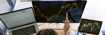 stock exchange trader working  with graphs,diagrams on monitor in modern trading office.