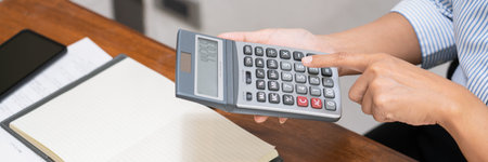 Concept of accounting work, business man doing paperwork using a calculator at the office and...