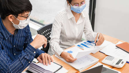 Group of Teamwork Asian business People Wearing Protective face Mask In Office During Pandemic coronavirus COVID-19, New Normal and Social distancing concept.の写真素材