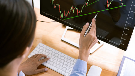 stock exchange trader working  with graphs,diagrams on monitor in modern trading office.