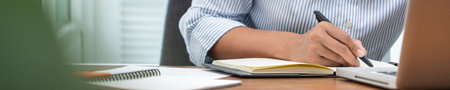 close up of Student learning online class by using laptop computer and writing notebook at...