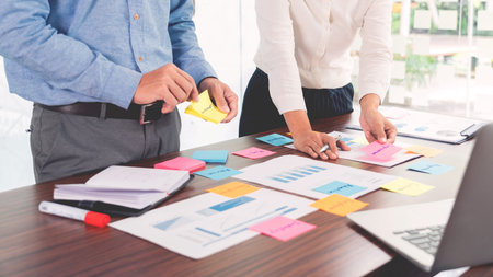 Businessman stick colorful notes to brainstorming on the table working on new project to share idea...