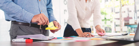 Creative group of business people brainstorming use sticky notes picking to share idea on table...