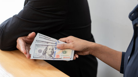 Businessman reciving money United States Dollars bills to corruption from his partner in business at...