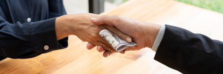 Businessman reciving money United States Dollars bills to corruption from his partner in business at...
