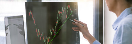 stock exchange trader working  with graphs,diagrams on monitor in modern trading office.