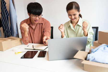 Asian business couple owner working at home with packing box of their online store prepare to deliver products to customers, alpha generation life style conceptの写真素材