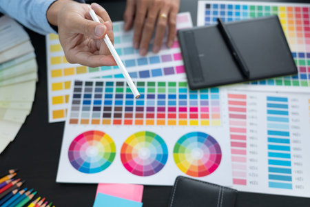 Graphic designer or creative working together coloring using graphics tablet and a stylus at desk...