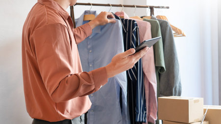 Asian business owner working at home with packing box of his online store prepare to deliver...