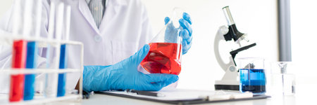 scientists researching in laboratory in white lab coat, gloves analysing, looking at test tubes...