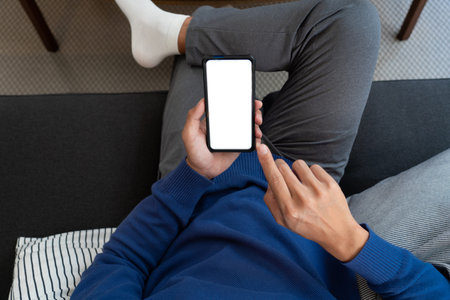 Handsome Asian teenager man wearing casual clothes in glasses using smart phone browsing Internet on...