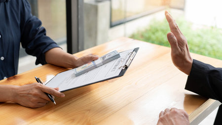 Confident businessman manager rejecting an offer of money to agreement contract from partner or refusing to take bribe, Bribery and corruption conceptの写真素材