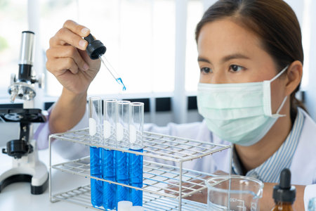 scientists researching in laboratory in white lab coat, gloves analysing, looking at test tubes...