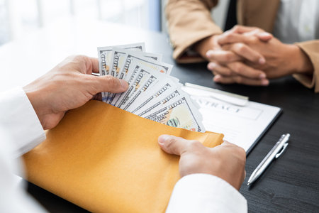 A male agent giving his greedy partner a cash for getting a favor in return.