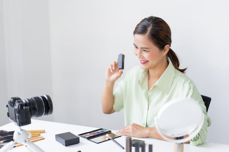 A female blogger working on the camera filming how to do wearable and trendy makeup tutorials.の写真素材