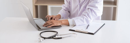A female doctor reading and interpreting laboratory results performing diagnostics to determine the...