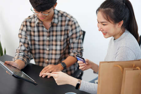 Shopping online concept a lovely couple adding credit card information to use in online financial transaction.の写真素材