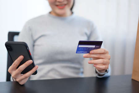 Shopping online concept a female shopper enjoys picking and purchasing products in an online shop.の写真素材