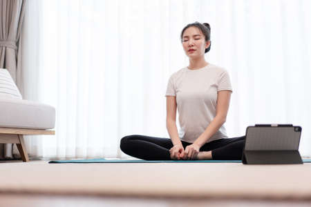 Productive activity concept a calm girl concentrating on meditating alone among peaceful atmosphere in the living room.の写真素材