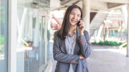 Working woman concept a working woman with smiley face speaking on the phone with her business partner.の写真素材