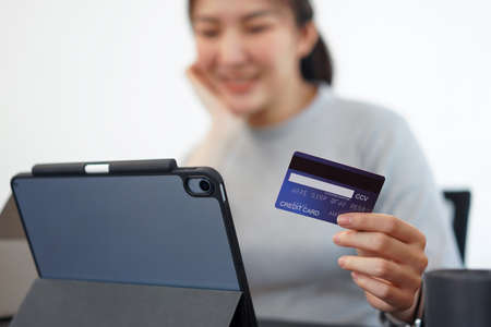 Shopping online concept a young woman using her credit card to facilitate   an online purchasing in online shopping application.の写真素材