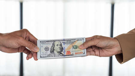 two hands passing bills making agreement to initiate the new business.の写真素材