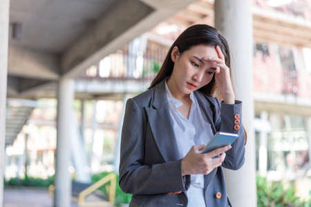 Working woman concept a young businesswoman fatigued after doing a load of work and spending too much time on electronic devices.の写真素材