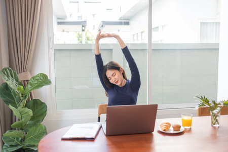 Work from home concept a female entrepreneur being relaxed stretching her arms while working...
