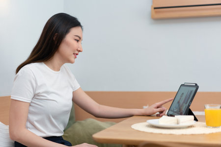 Living room concept a woman using her electronic device to work remotely in the cozy room of the coffee shop.の写真素材
