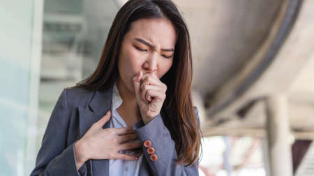 Working woman concept a working woman coughing after contacting with many people while working without any protection.の写真素材