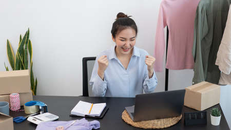 Live shopping concept a female seller feeling delighted to her success after the sale reaching the goal.の写真素材
